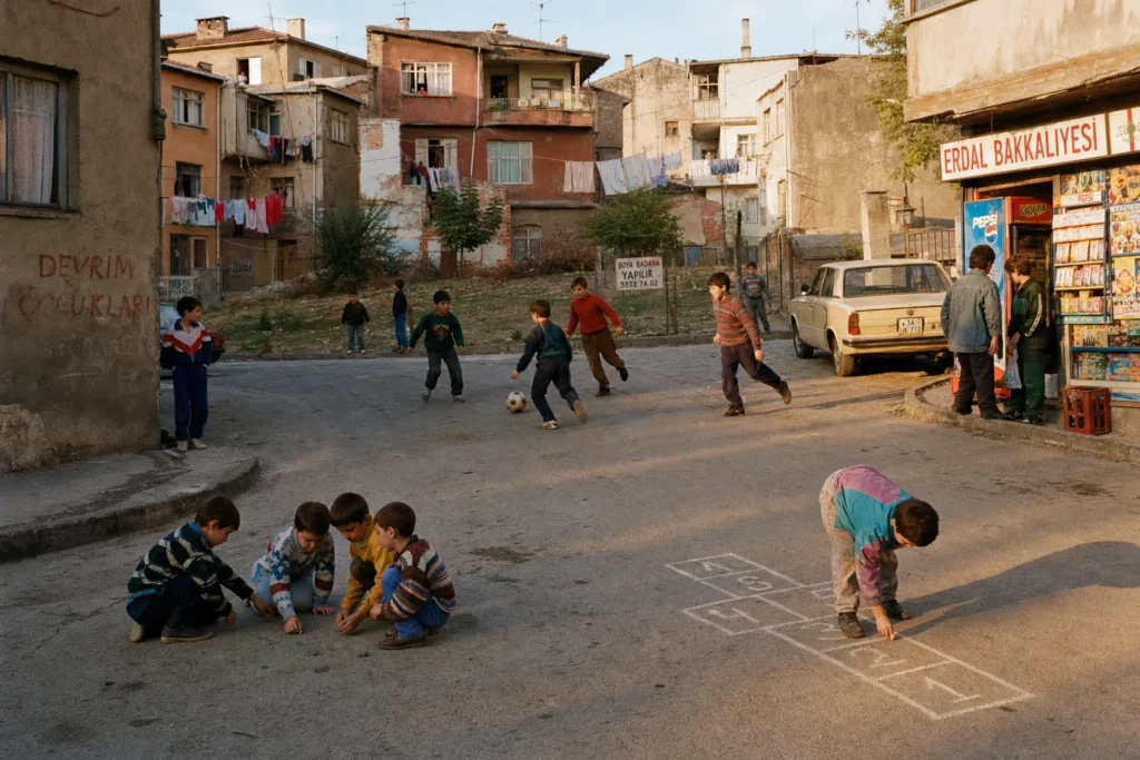 Eski bir mahalle sokağında çocuklar top, misket ve sek sek oynuyor. Boş arsa, okul duvarı, kaldırım kenarı ve açık pencereler görünüyor. Ortam canlı ama abartısız; sıcak yaz sonu ışığı, solmuş film renkleri, nostaljik Türkiye mahalle atmosferi.